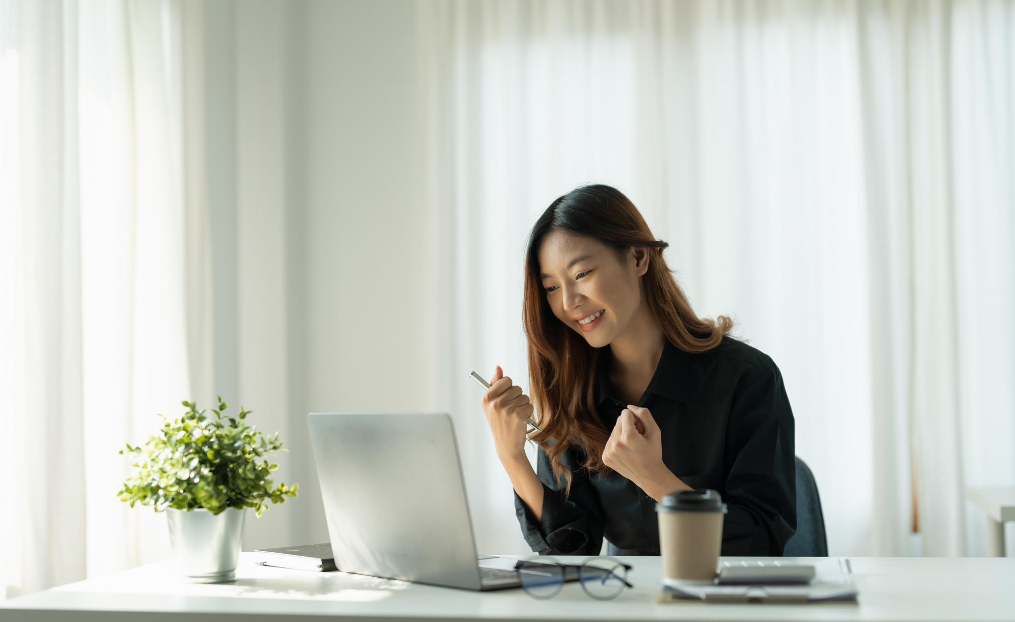 Portrait of happy young business asian woman celebrating suc